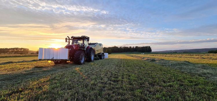 Traktorn är en Case IH 150 Maxxum och pressen är en Krone Comprima CV150XC Plus. Martin Knutsson har rejält med plast i fronten på traktorn.