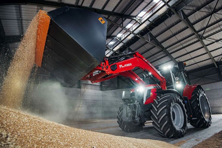 Traktor lastar spannmål.
