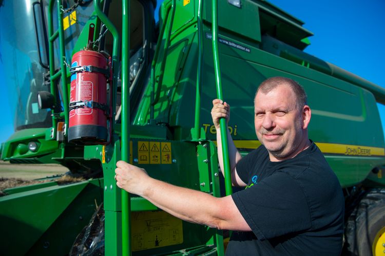Erik Bäckström framför sin John Deere T 670i.