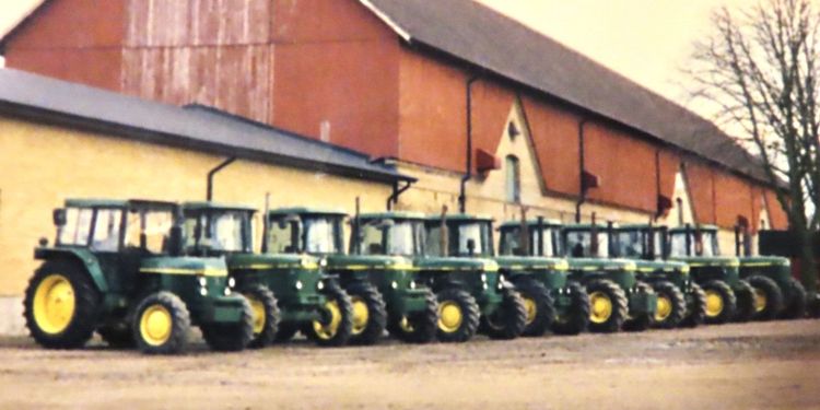 Nio av Säbyholms gårds elva John Deere står uppradade framför kostallet. Det är många rundhytter eller SG2-hytter som de egentligen heter.